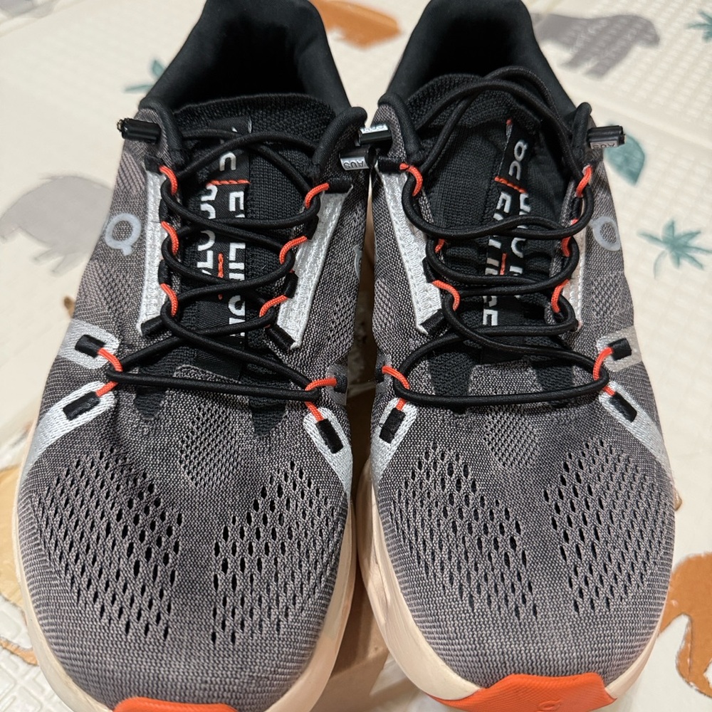 On Running Women’s Gray and Black Running Shoes with Orange Accents